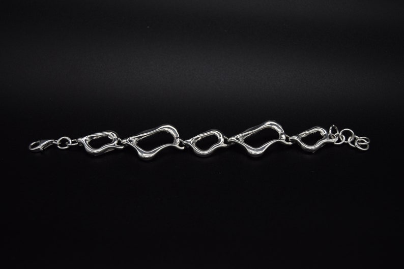 Asymetrical silver bracelet large and small link .