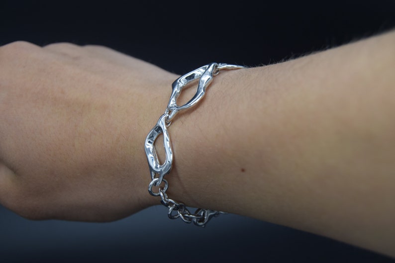 Asymetrical silver bracelet large and small link .