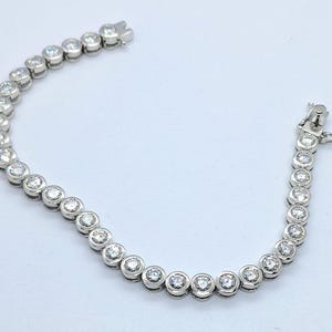 Pulsera de tenis redonda de moissanita: platino sobre engaste de plata de ley