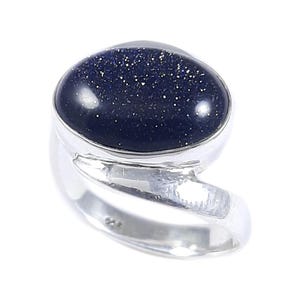 Könnte beinhalten: Ein Silberring mit einem großen, ovalen, dunkelblauen Edelstein mit funkelnden Einschlüssen. Der Ring hat ein fließendes, offenes Design. Der Edelstein ist in einer polierten Silberfassung gefasst.