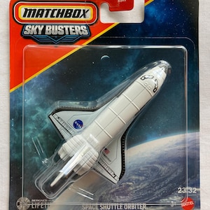 May include: A Matchbox Sky Busters Space Shuttle Orbiter toy in its original packaging. The white shuttle features the NASA logo and the name Endeavour. The card backing displays a space scene with Earth and the text Space Shuttle Orbiter.