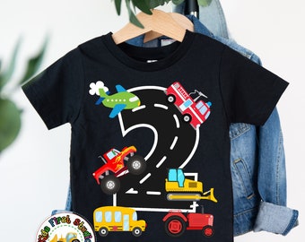 May include: Black t-shirt with a number two design featuring a road with a fire truck, monster truck, airplane, bulldozer, and tractor. The shirt has the text "Kids First Studio Things Kids Love" on the bottom.