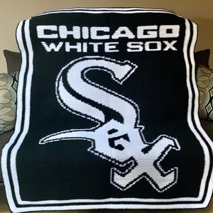 May include: Black and white crocheted throw blanket with the Chicago White Sox logo. The logo is a white 'S' with a black outline and a white 'C' with a black outline.