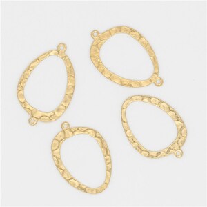 May include: Four gold-toned metal oval-shaped pendant blanks with a textured surface. Each blank has two small holes at the top for attaching a jump ring or other jewelry findings.