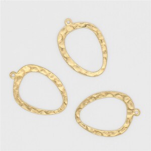 May include: Three gold-toned metal pendant charms with a hammered texture and an oval shape. Each charm has a small loop at the top for attaching to jewelry.
