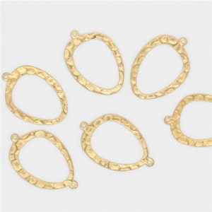 May include: Six gold-toned metal oval-shaped pendant charms with a hammered texture. Each charm has a loop at the top for attaching to jewelry.