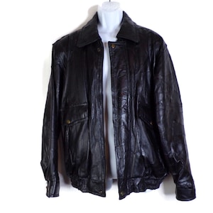 May include: A black leather bomber jacket with a zipper closure and two flap pockets.