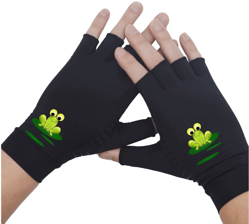 K&ouml;nnte beinhalten: Schwarze fingerlose Handschuhe mit einem gr&uuml;nen Frosch-Design auf jedem Handschuh. Der Frosch sitzt auf einem Seerosenblatt.
