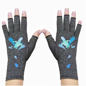 May include: A pair of gray fingerless gloves with a blue and green turtle design. The gloves have a black trim around the finger openings.