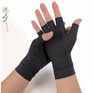 K&ouml;nnte beinhalten: Ein Paar schwarze fingerlose Kompressionshandschuhe mit einem strukturierten Design. Die Handschuhe werden an den H&auml;nden einer Person getragen.