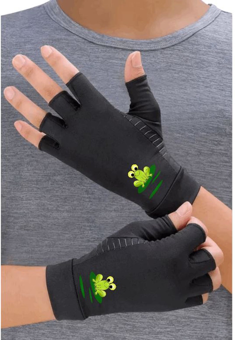 K&ouml;nnte beinhalten: Ein Paar schwarze Fingerlose Handschuhe mit einem gr&uuml;nen Frosch-Design auf jedem Handschuh. Der Frosch hat gro&szlig;e Augen und sitzt auf einem gr&uuml;nen Seerosenblatt.