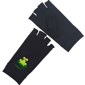 K&ouml;nnte beinhalten: Ein Paar schwarze Fingerlose Handschuhe mit einem gr&uuml;nen Frosch-Motiv auf einem Handschuh. Die Handschuhe haben ein gestreiftes Muster und sind aus atmungsaktivem Material.