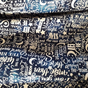 May include: A navy blue fabric with a white and gold print of stars, moons, and words related to the night sky. The words include "Love You to the Stars", "Moon", "Star", "Shine", "The Night", "We Belong Among the Stars", and "Let's Go".
