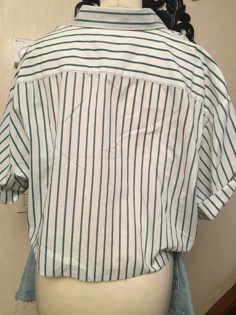 Peut inclure: Une chemise &agrave; manches courtes boutonn&eacute;e &agrave; rayures blanches et vertes avec une coupe d&eacute;contract&eacute;e.