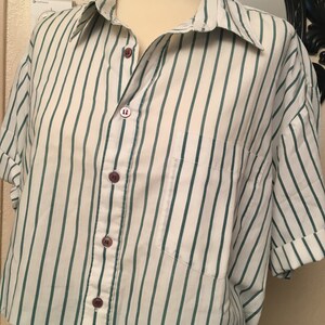 Peut inclure: Une chemise &agrave; manches courtes boutonn&eacute;e &agrave; rayures blanches et vertes avec un ourlet court.