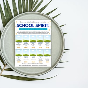 Puede incluir: Un folleto en un plato gris con el texto "SCHOOL SPIRIT!" e im&aacute;genes de productos. El folleto enumera art&iacute;culos como camisetas de manga corta, sudaderas con capucha y gorras de b&eacute;isbol. El folleto est&aacute; rodeado de hojas verdes.