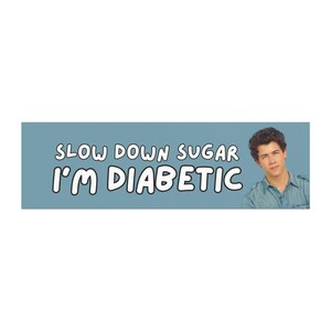 May include: A light blue banner with the text "SLOW DOWN SUGAR I'M DIABETIC" in white, bold font. A young man with dark hair is on the right side of the banner.
