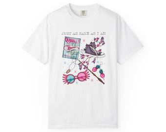 May include: A white t-shirt featuring a graphic print with the text "JUST AS SANE AS I AM" above illustrations of a magazine, a high-top sneaker, pink-rimmed glasses, a wand, and radish-shaped earrings, all accented with small star motifs.