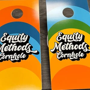 May include: Two rectangular cornhole boards featuring a circular hole at the top. The boards display a colorful arched design in orange, blue, and green. The text Equity Methods Cornhole is printed in a bold white script font with a black shadow.