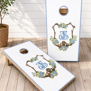 the perfect personalized wedding gift, groomsman gift, or unique addition to your wedding celebration. This beautiful monogram cornhole set features a white finish with an elegant blue and white floral wreath surrounding your custom monogram.  Each custom game board is personalized with your initials, making it a one-of-a-kind keepsake. Whether you're looking for custom logo boards a cornhole score board or stylish corn hole boards, this premium cornhole board set is built to impress.
