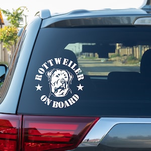 Könnte beinhalten: Weißer Autoaufkleber aus Vinyl mit dem Kopf eines Rottweilers und dem Text "Rottweiler On Board" in einem Kreis.