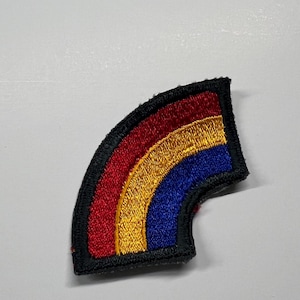 May include: Embroidered rainbow patch with a black border. The rainbow features red, yellow, and blue stripes. This patch can be sewn or ironed onto clothing, bags, or other fabric items. Great for adding a pop of color and personality.