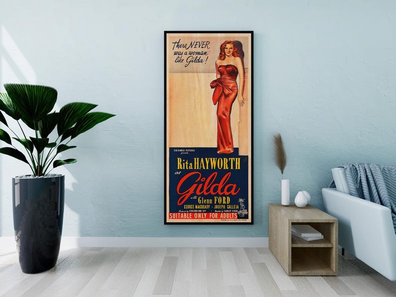 a framed vintage poster of a woman in a red dress, hanging on a wall in a living room setting.