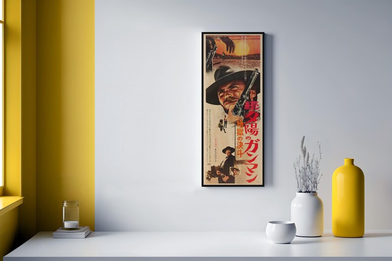 a framed poster of a man with a cowboy hat, displayed on a wall next to a white table with various decorative items, including a yellow vase and a small white bowl.