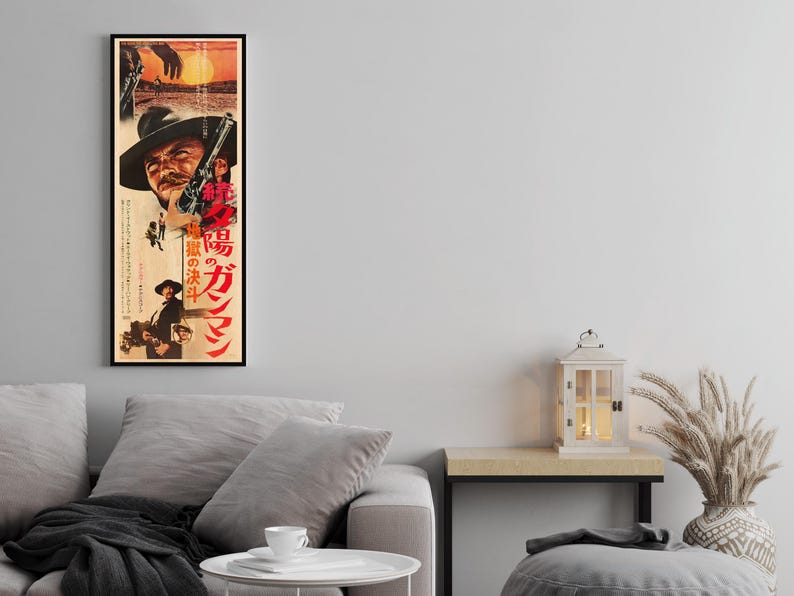 a living room with a gray sofa, a small table, and a decorative lantern. There is also a framed poster of a movie on the wall above the sofa.