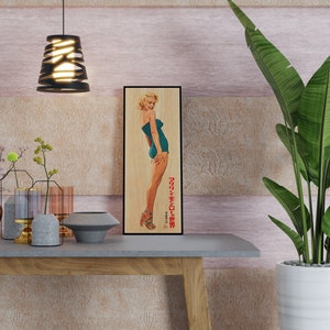 a picture of a woman in a bathing suit on a shelf next to a plant