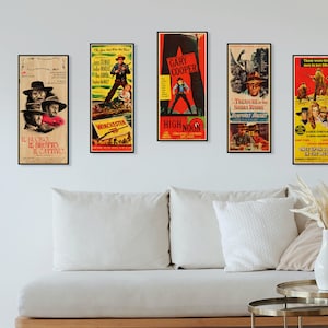 May include: Five vintage movie posters featuring classic Western films. The posters are framed and hung on a white wall above a white couch with pillows. The posters feature titles like "Winchester 73", "High Noon", "The Good, the Bad and the Ugly", "Treasure of the Sierra Madre", and "Once Upon a Time in the West".