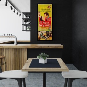 a kitchen with a table and chairs and a poster on the wall