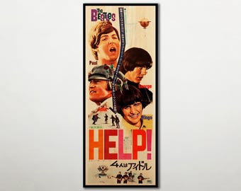 May include: A vertical movie poster for The Beatles film Help! featuring portraits of Paul, John, George, and Ringo. The design includes the band name in purple, the title HELP! in large red letters, and Japanese text throughout the cream background.