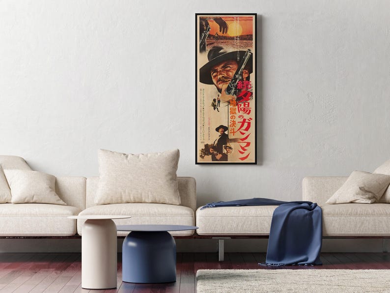 a living room with a large framed poster of a man on the wall, a white sofa, a blue side table, and a blue blanket on the sofa.