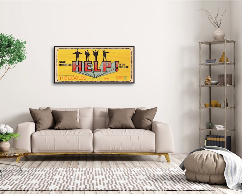 Puede incluir: Un p&oacute;ster de pel&iacute;cula vintage para la pel&iacute;cula de los Beatles "Help!" El p&oacute;ster presenta un fondo amarillo con los Beatles en silueta de pie sobre una pila de libros. El texto "Help!" est&aacute; en letras rojas y blancas, y los textos "Stop Worrying!" y "It's on the way!" est&aacute;n en letras negras.