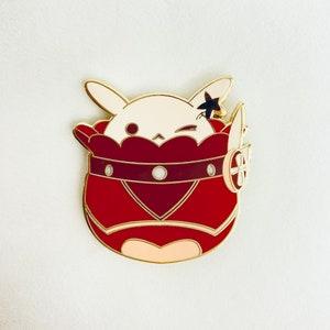 Puede incluir: Un conejito blanco con un disfraz rojo en forma de corazón y una estrella dorada en la cabeza. El conejito lleva un cinturón dorado con una gema blanca. El conejito está guiñando un ojo.