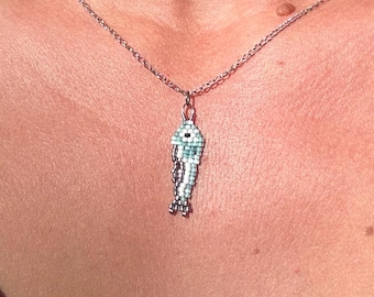 Colgante de collar con colgante de pez sardina pequeño, azul y plateado, hecho a mano con cuentas tejidas.