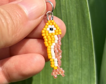 Colgante de collar con colgante de sardina pequeña de cuentas rosas y amarillas, hecho a mano con cuentas de semillas tejidas.