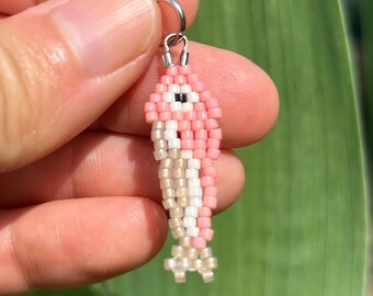 Colgante de collar con colgante de pez sardina pequeño de color rosa claro, hecho a mano con cuentas tejidas.