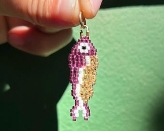 Colgante de sardina con cuentas moradas y doradas, hecho a mano con cuentas tejidas.