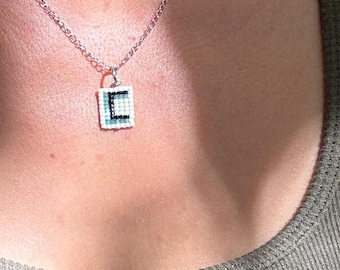 Colgante de collar con inicial de la letra C azul, hecho a mano con cuentas de semillas tejidas.