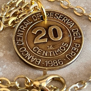 Könnte beinhalten: Eine goldene Kettenkette mit einem 20-Centimos-Münzenanhänger der Banco Central de Reserva del Peru. Die Münze ist mit 1986 datiert.