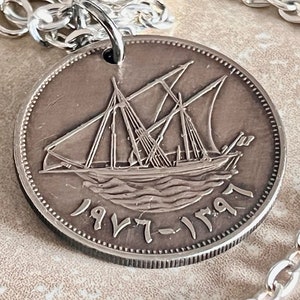 May include: Silver pendant necklace featuring a vintage coin with a detailed engraving of a sailing ship and the years "1977-1997".