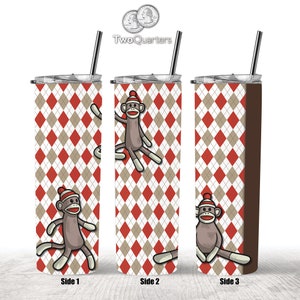 May include: A stainless steel tumbler with a brown, red, and white argyle pattern. The tumbler has a straw and features a cartoon sock monkey wearing a red and white hat on each side. The text "Side 1", "Side 2", and "Side 3" is printed below each side of the tumbler.