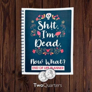 May include: A spiral-bound planner with a dark teal cover featuring the text "Sh!t, I'm Dead. Now What?" and "End of Life Planner." The design includes a skull, flowers, and hearts. Two quarter coins are placed below the planner.