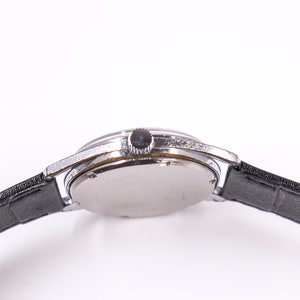May include: A silver wristwatch with a black leather band. The watch has a round face and a silver case.