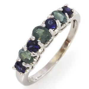 May include: A silver band ring with alternating blue and green oval gemstones.