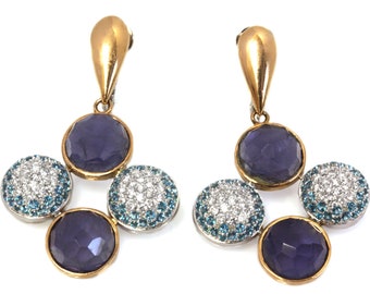 May include: A pair of gold dangle earrings with a cluster of four round stones. The stones are a mix of clear, blue, and purple.