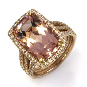 May include: A gold ring with a large, rectangular, light pink gemstone surrounded by a halo of smaller diamonds. The ring band is also set with diamonds.