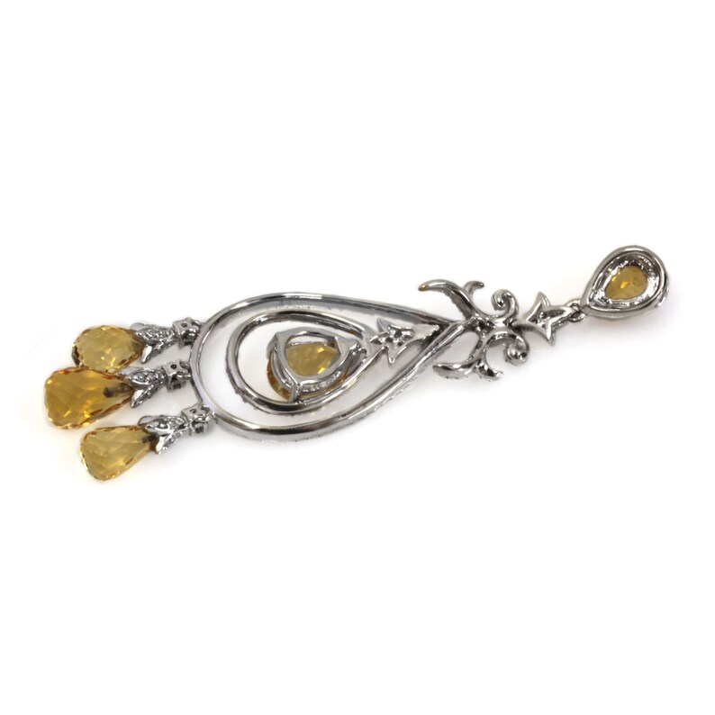 May include: A silver dangle earring with a teardrop-shaped design and multiple yellow gemstones.